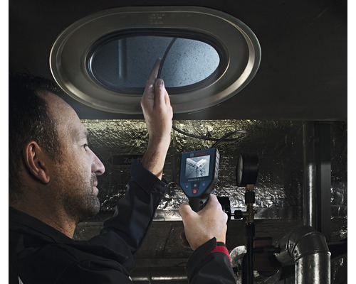 En man använder en inspektionskamera för att inspektera en öppning.