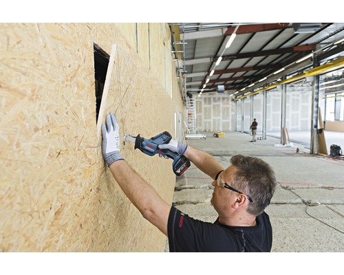 Hantverkare sågar ett hål i en träskiva med en batteridriven tigersåg.