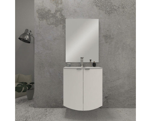 Badrum med tvättställsskåp, spegel och armatur framför en vägg