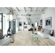 Ljust, öppet vardagsrum med trägolv, soffa och dekorativ belysning