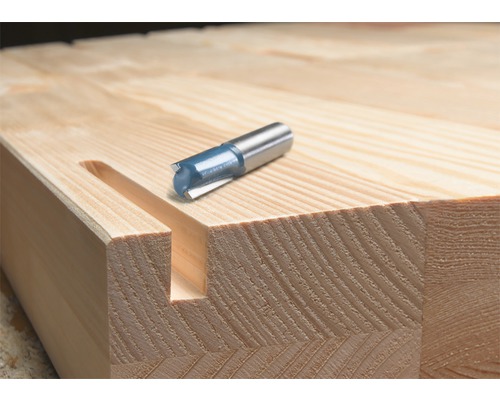 Spårfräs bredvid en träplatta med fräst spår