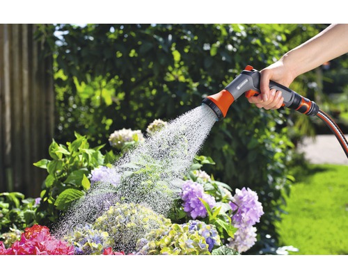 Trädgårdsbevattning med handdusch på en trädgårdsslang