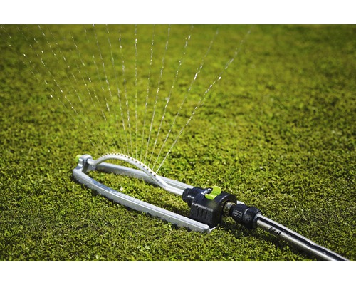 Grässpridare vattnar en gräsmatta