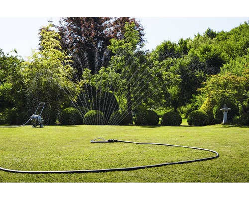 Trädgårdsbevattning med grässpridare och slangvagn