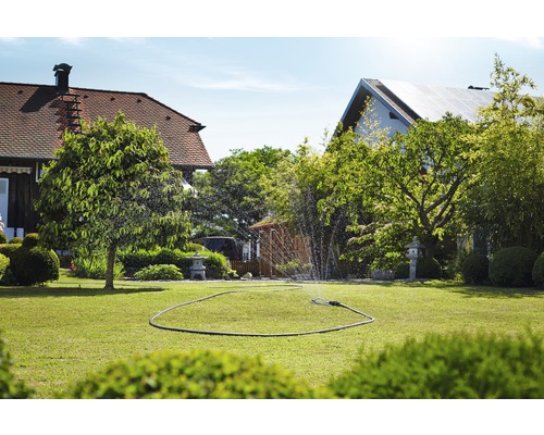 Bevattnad gräsmatta med grässprinkler i en trädgård.