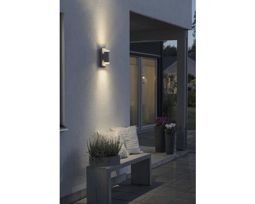 Uteplats med vägglampa, sittbänk och växter