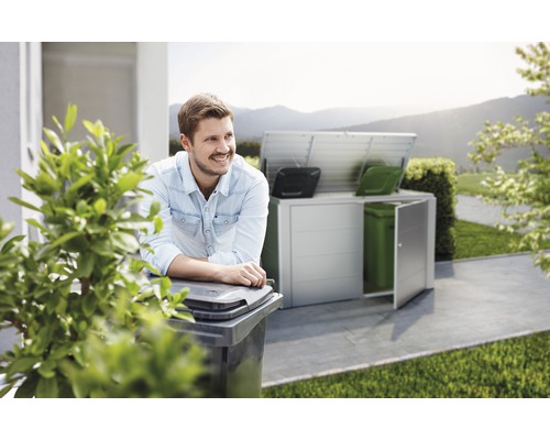 Scen med en man som lutar sig mot en soptunna och ett soptunneskåp i bakgrunden.