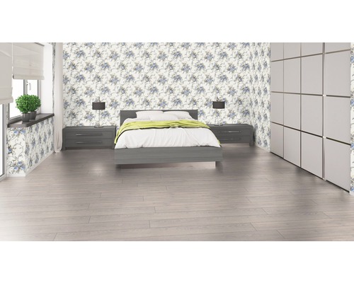 Sovrum med säng, sängbord, lampor, garderob och blommig tapet.