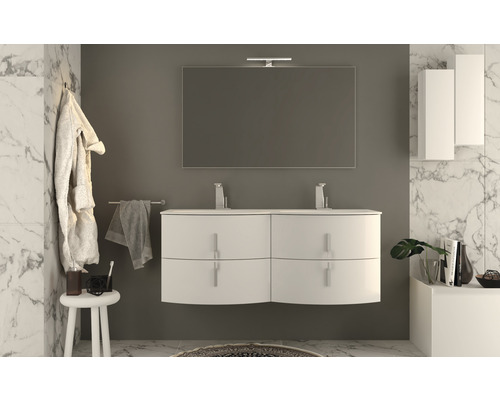 Modernt badrum med vitt handfat, spegel och badrumsmöbler framför marmorvägg