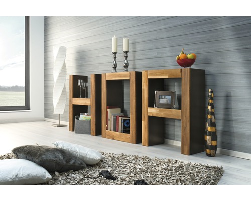 Vardagsrumsscen med träbokhylla, dekorativa föremål och kuddar på en matta.