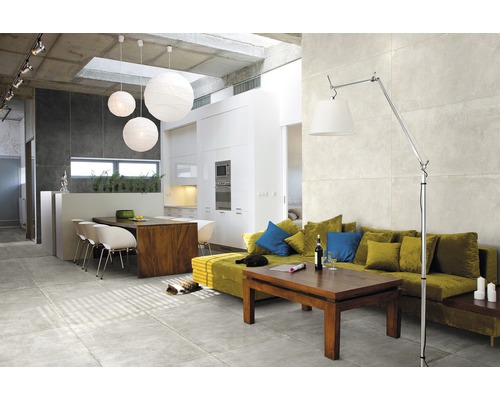 Ljust vardagsrum med golvplattor, soffa, bord och belysning