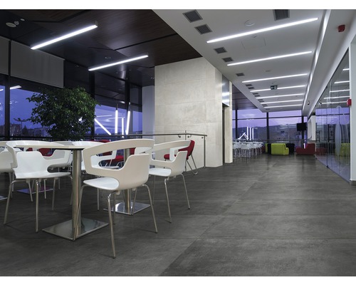 Interiör med sittplatser, bord och storformatiga golvplattor för en modern atmosfär.