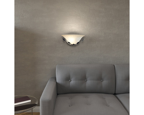 Vägglampa med blommiga detaljer ovanför soffa