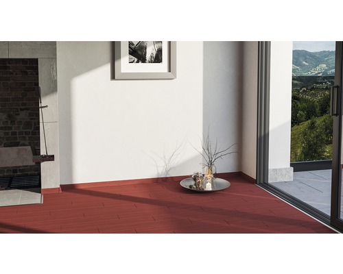 Ljust rum med rött trägolv, altandörr och dekorativa element.