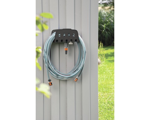 Trädgårdsslang på slanghållare på en vägg