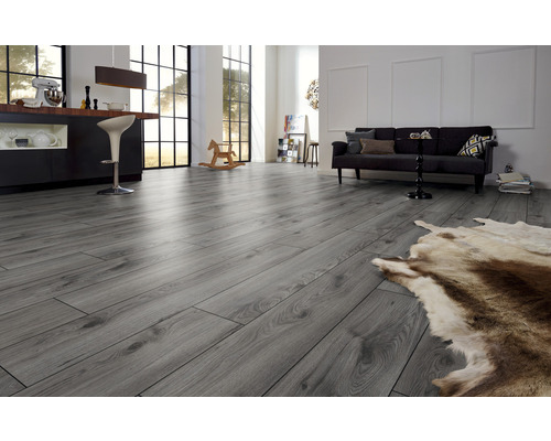 Ljust rum med grått laminatgolv, soffa och bar