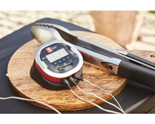 Weber iGrill grilltermometer med grilltång på en träbräda