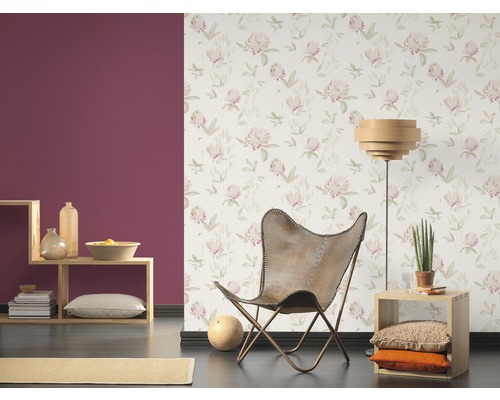 Vardagsrum med blommig tapet, fåtölj och dekoration på hyllor