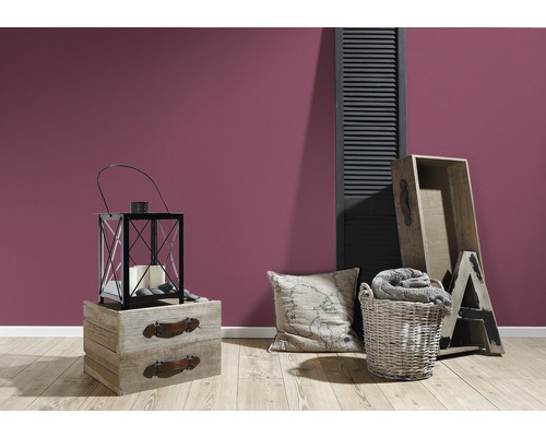 Dekorativt vardagsrum med lykta, kudde och träelement framför en vägg