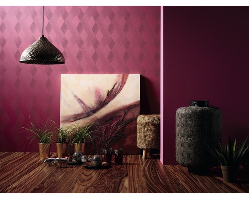 Interiörvy med mönstrad tapet, hängande lampa, målning och dekorationer på ett trägolv.