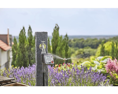 Trädgårdsscen med vattenkran och elektronisk bevattningskontroll