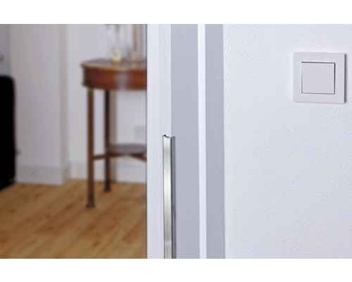 Närbild av en dörrkarm med kantskydd och en strömbrytare på väggen.