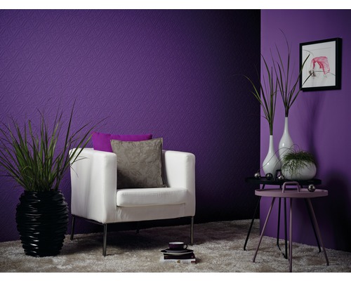 Dekorativt vardagsrum med lila tapeter, fåtölj, sidobord och krukväxter.