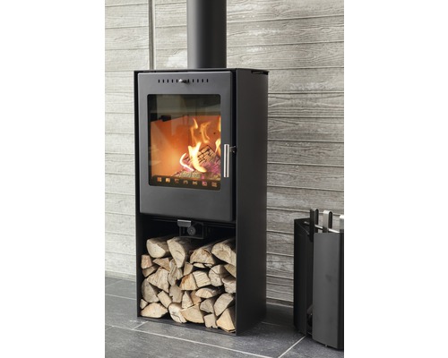 Svart vedeldad kamin med ved och eldstadsredskap