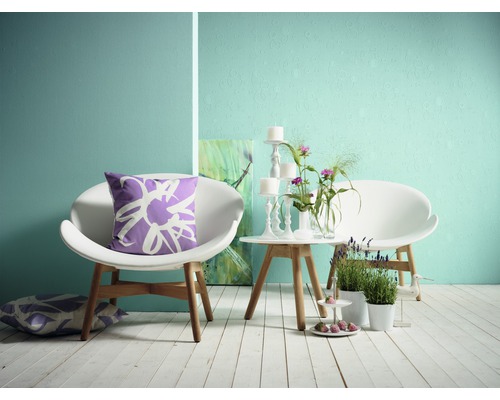 Vardagsrum med två stolar, ett bord, dekoration och kuddar