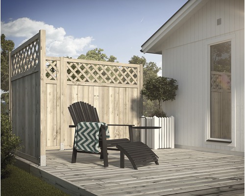 Trästaket med rombmönster bredvid ett trähus med stol och sidobord på en terrass