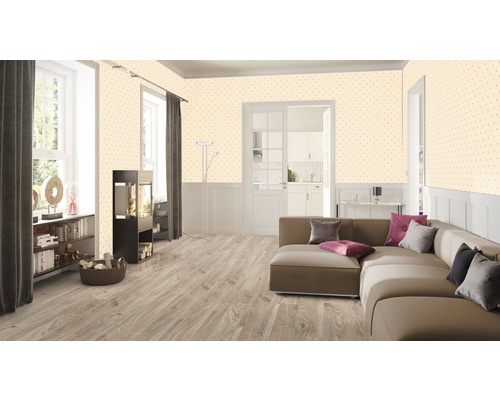 Vardagsrum med soffa, bokhylla och mönstrad tapet