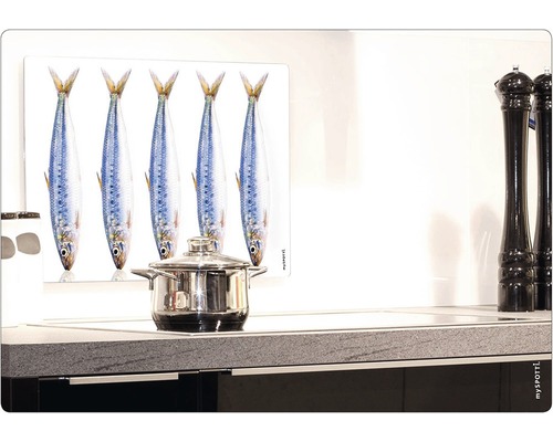 Spisplatta med fiskmotiv och en kastrull på en spis.