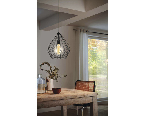Matsal med träbord och svart hänglampa i tråddesign