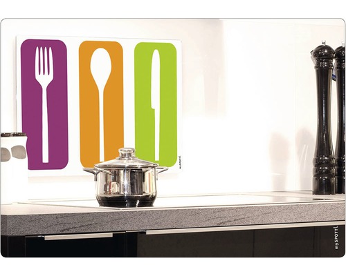 Köksscen med kastrull på spis och köksstänkskydd med motiv av knivar, gafflar och skedar