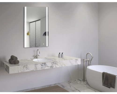 Ljust badrum med spegel, handfat och badkar