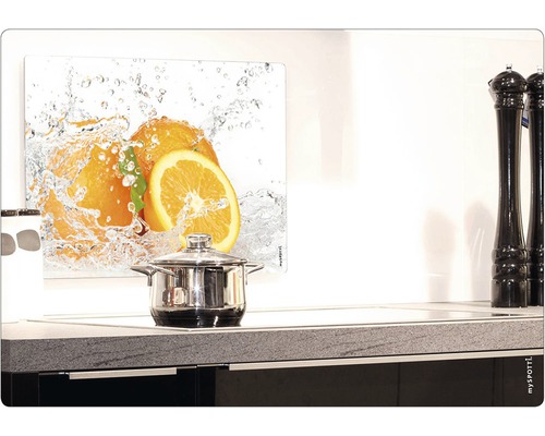 Köksscen med stänkskydd med apelsinmotiv bakom spishällen