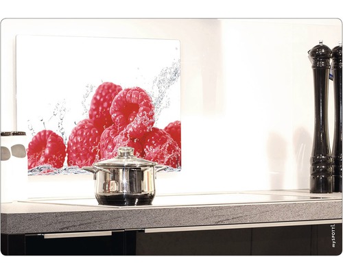 Köksscen med kastrull på spishäll och stänkskydd med hallonmotiv