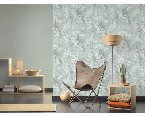 Vardagsrum med mönstrad tapet, trämöbel och läderfåtölj