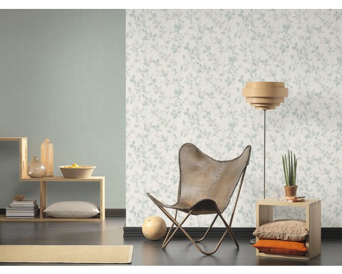 Vardagsrum med blommönstrad tapet, fåtölj och träelement