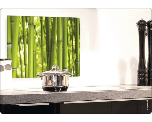 Köksvägg med bambumotiv ovanför en kastrull på en spis