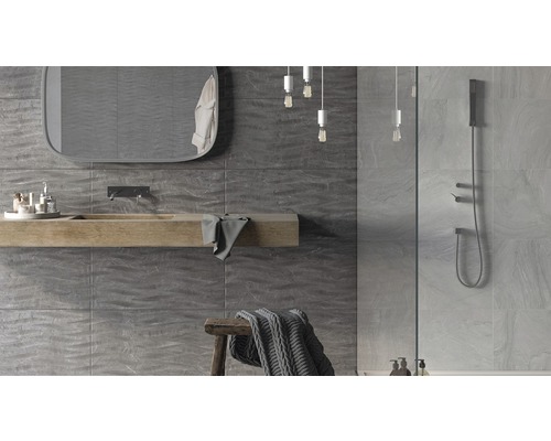 Modernt badrum med grå väggplattor, tvättställ i trä, spegel och dusch.