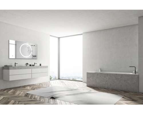 Ljust badrum med tvättställ, spegel med belysning och badkar