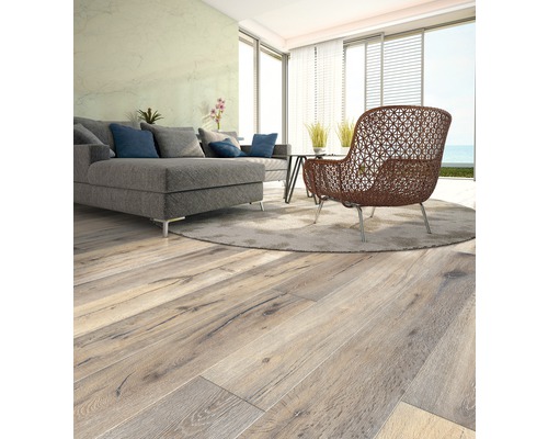 Ljust vardagsrum med trägolv, soffa och fåtölj