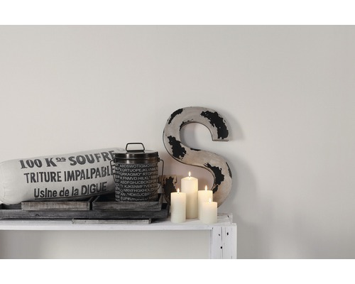 Dekoration med kudde, behållare, ljus och bokstav på en hylla