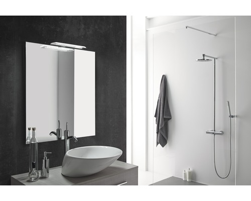 Modernt badrum med handfat, spegel, dusch och handduk