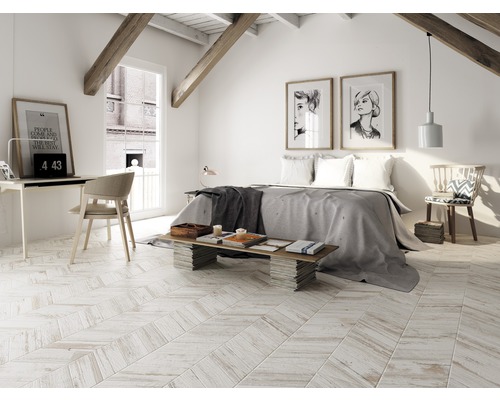 Ljust sovrum på vinden med säng, skrivbord och träbjälkar