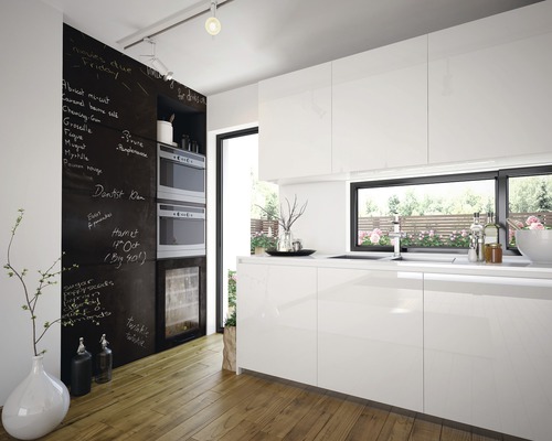 Modernt kök med vita skåp, griffeltavla och trägolv
