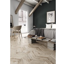 Ljust sovrum med snedtak, träbjälkar och fiskbensparkett