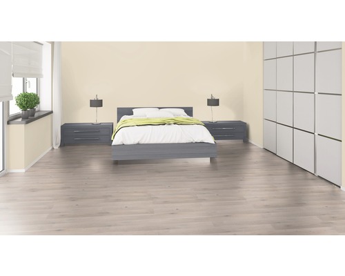 Ljust sovrum med säng, sängbord och garderob