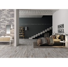 Ljust rum med trägolv, säng, trappa och tvättställ